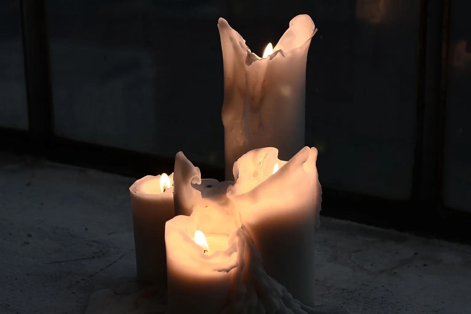 Burning candles with melted wax at night