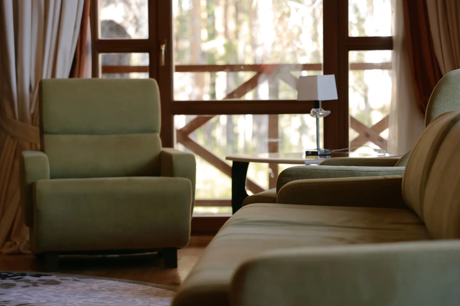 A cozy living room with green armchairs and carpeted flooring