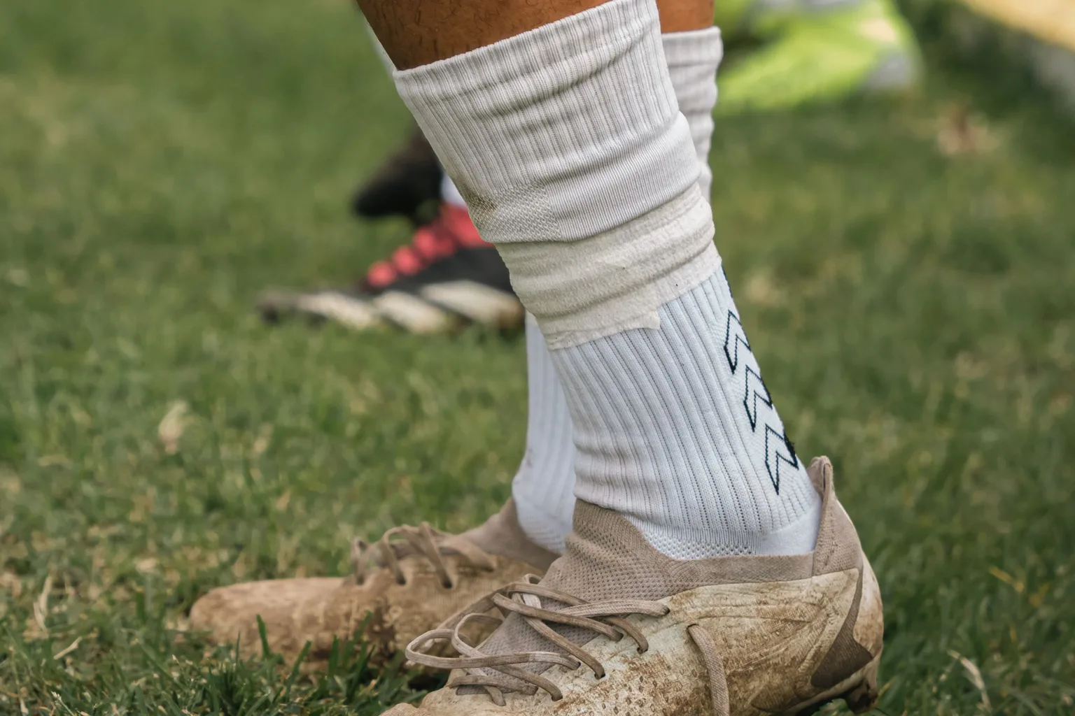 Close-up of a soccer player's cleats on a grass field