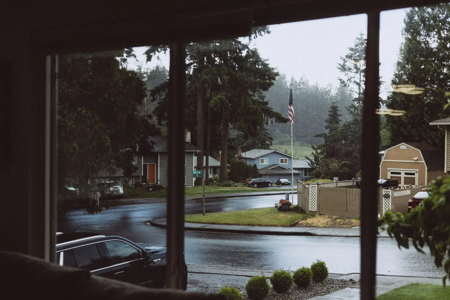 A suburban neighborhood street seen on a rainy autumn day