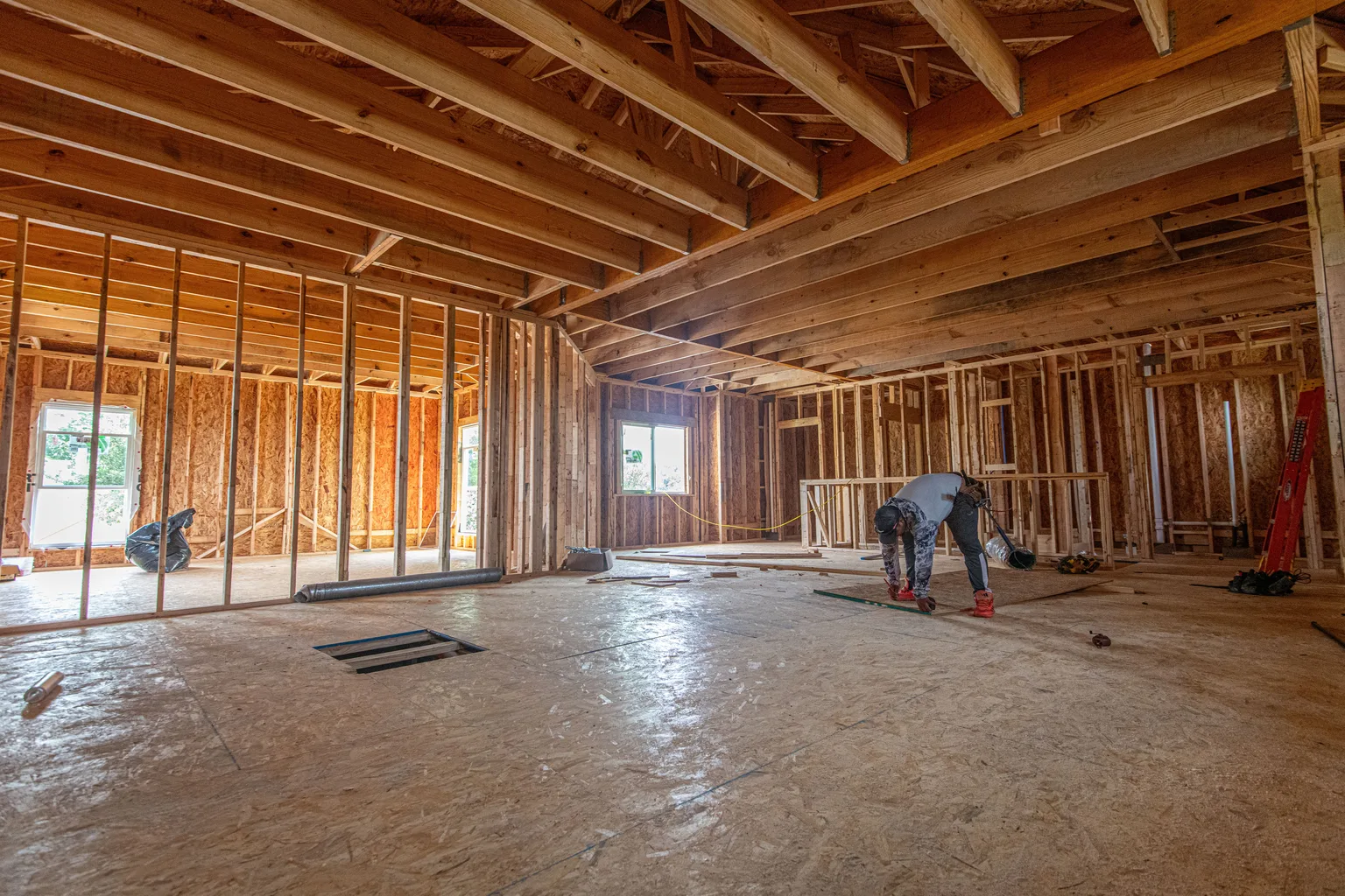 Interior of a house under construction with exposed framing and a subfloor
