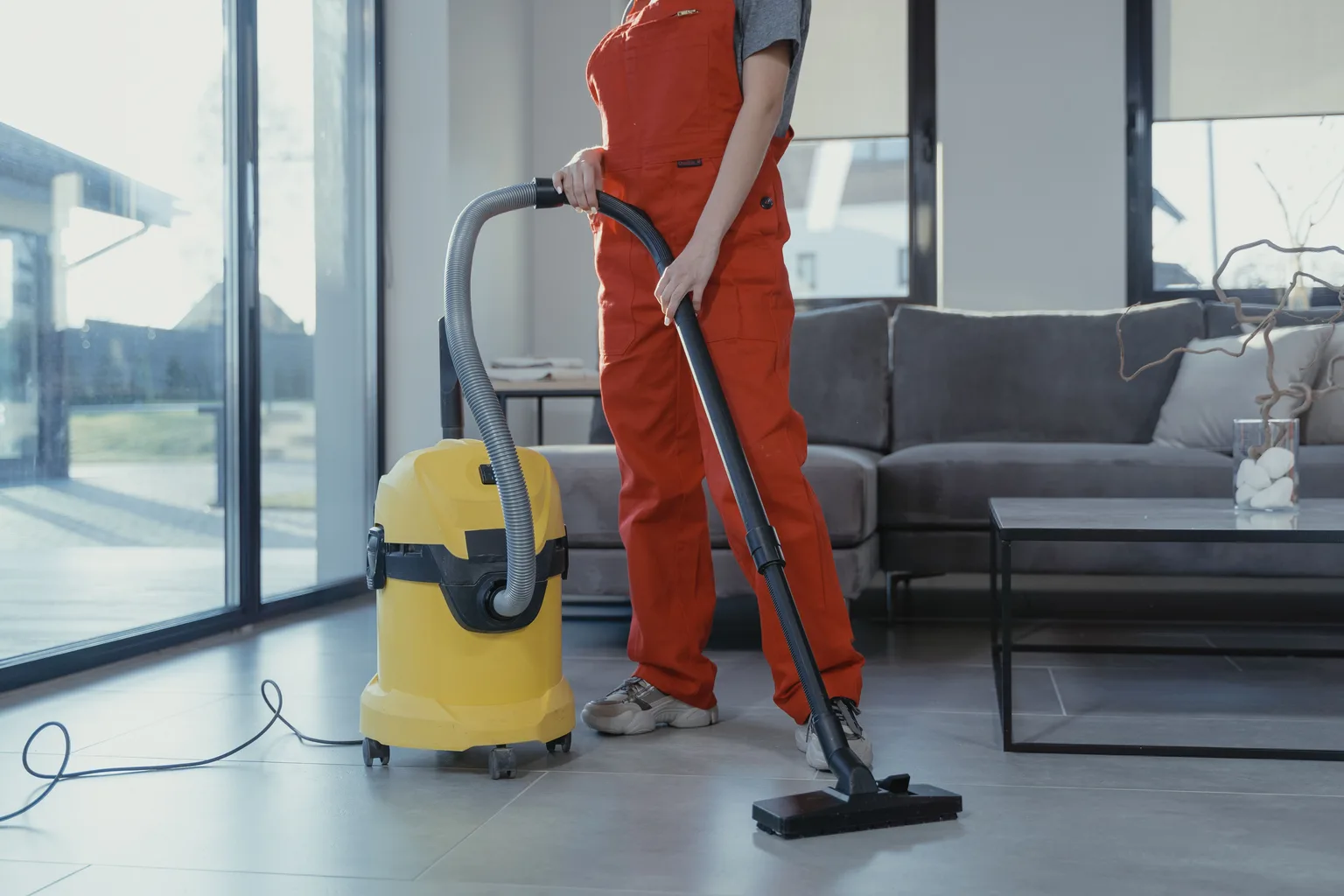 A professional cleaner working with equipment in a living room